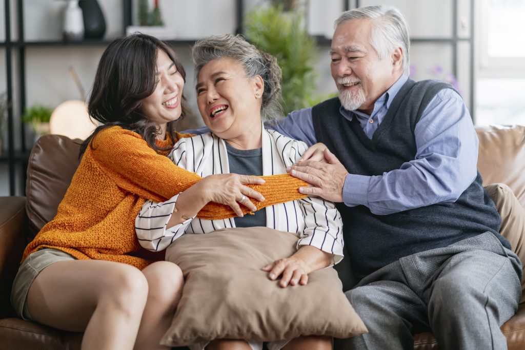 happiness-asian-family-candid-daughter-hug-grandparent-mother-farther-senior-elder-cozy-relax-sofa-couch-surprise-visiting-living-room-hometogether-hug-cheerful-asian-family-home-min